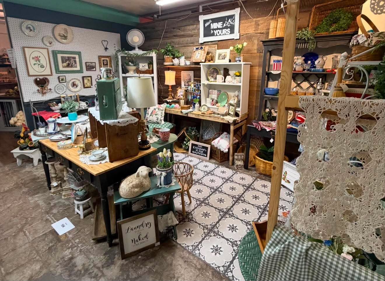 A cozy vendor booth filled with lamps, dishes, baskets and vintage home décor