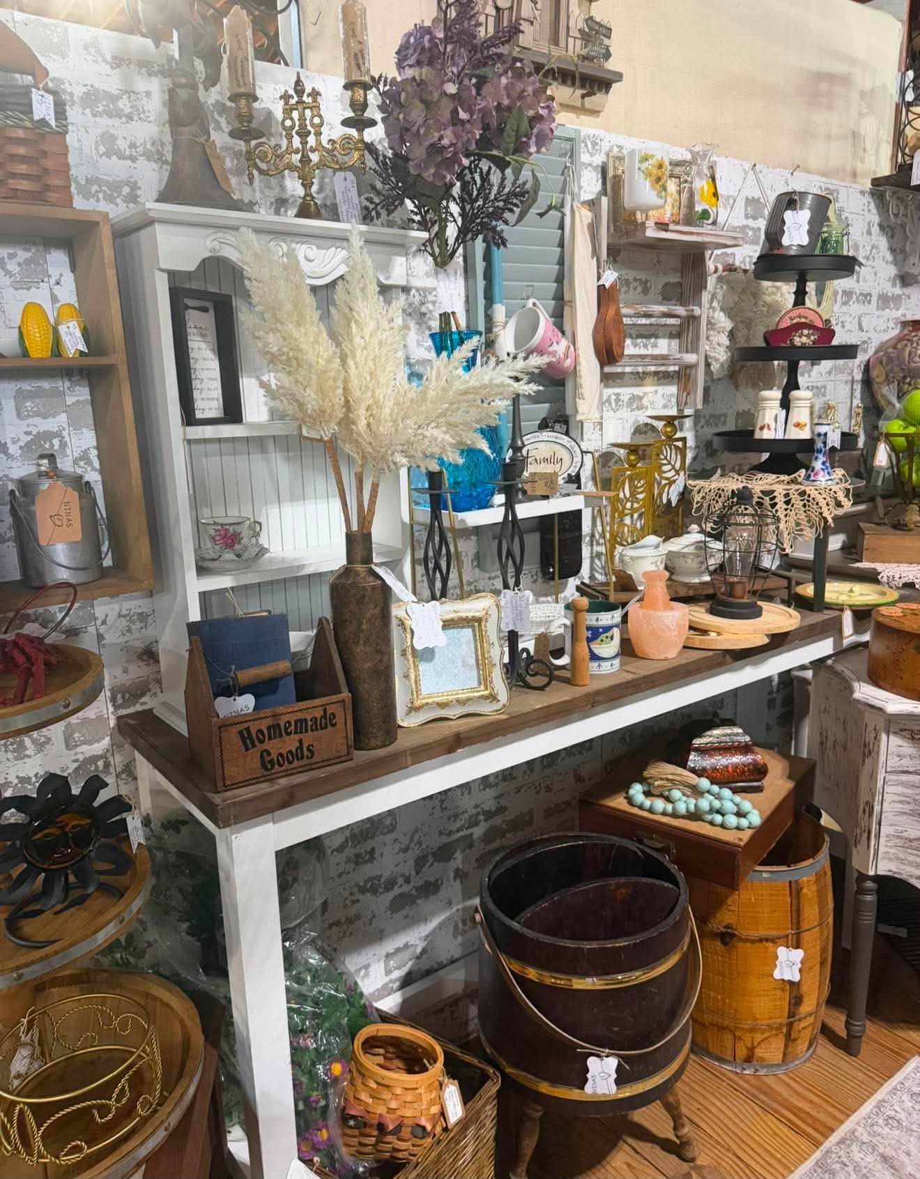 Layered vintage home décor including frames, baskets, pottery and candleholders