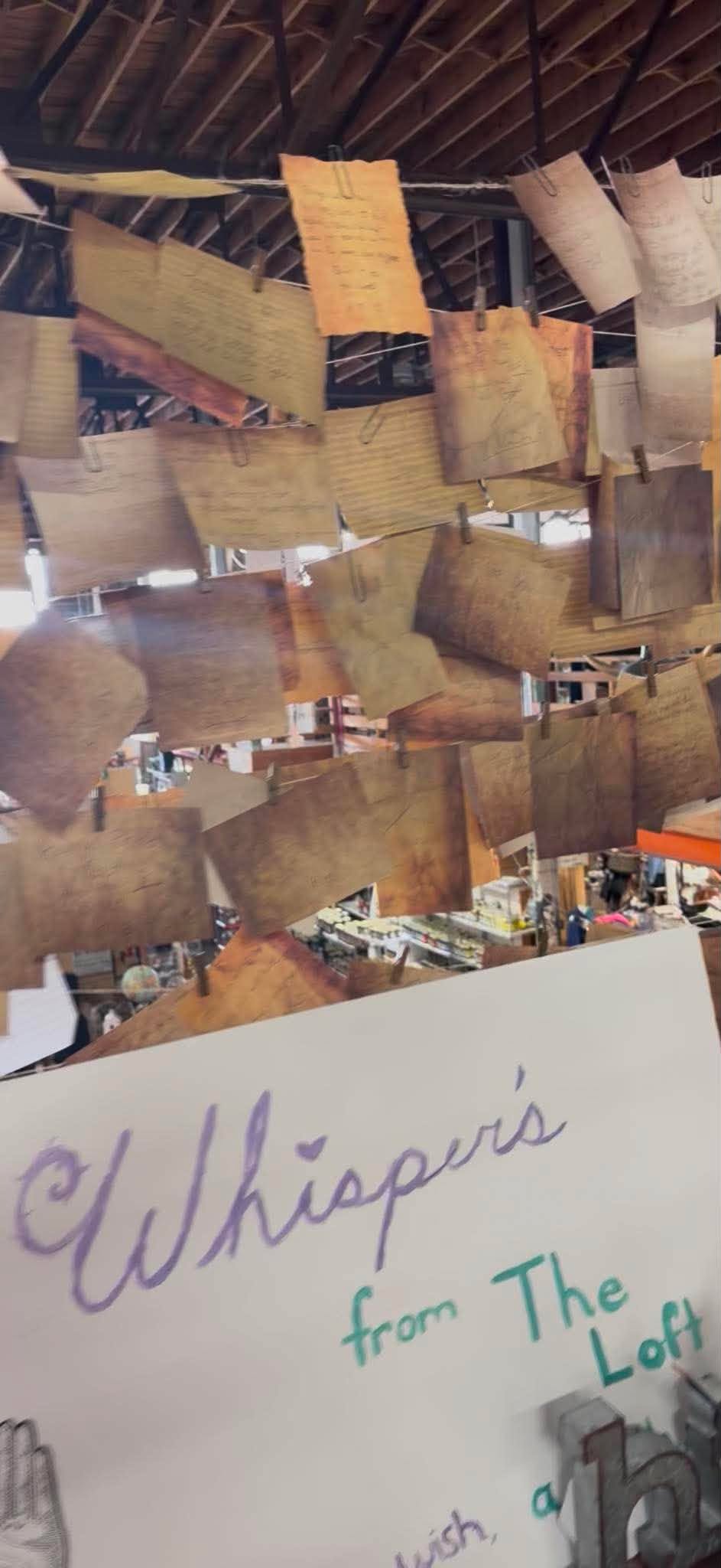 Handwritten messages hanging above Whispers from the Loft